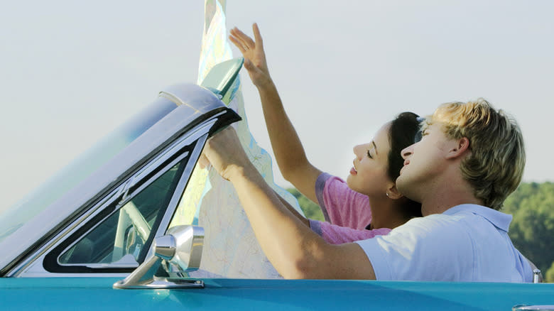 two people driving with map