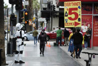 Costumed characters and merchants wait for pedestrians on Hollywood Boulevard, Thursday, March 12, 2020, in the Hollywood section of Los Angeles. (AP Photo/Chris Pizzello)