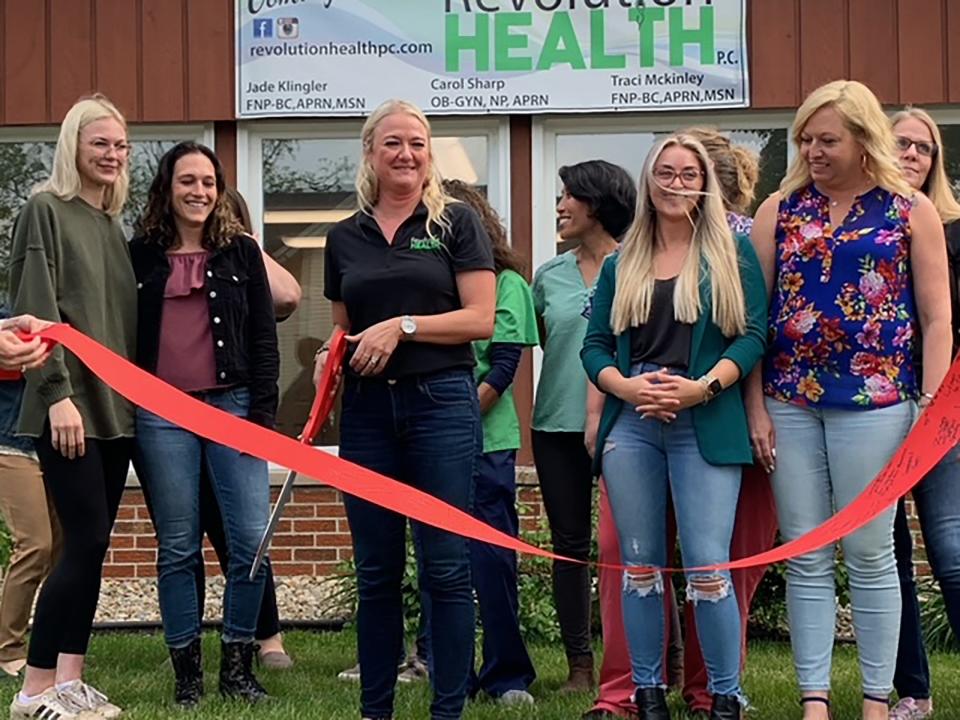 Jade Klinger, who recently opened Revolution Health in Colon, prepares for a ceremonial ribbon cutting Wednesday.