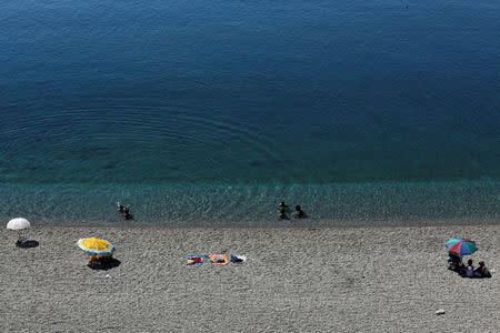 FILE PHOTO: Tourists enjoy a beach in the Turkish Mediterranean resort city of Antalya, a popular destination for both Turkish and European tourists, July 25, 2016. REUTERS/Kaan Soyturk/File Photo