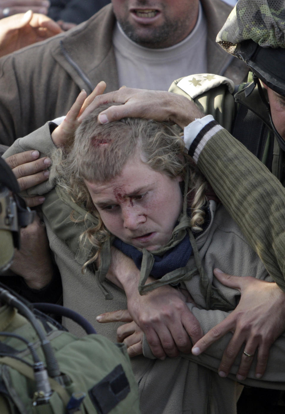 Israeli soldiers evacuate an Israeli settlers who was detained by Palestinian villagers in a building under construction near the West Bank village of Qusra, Jan. 7, 2014. (AP Photo/Nasser Ishtayeh)