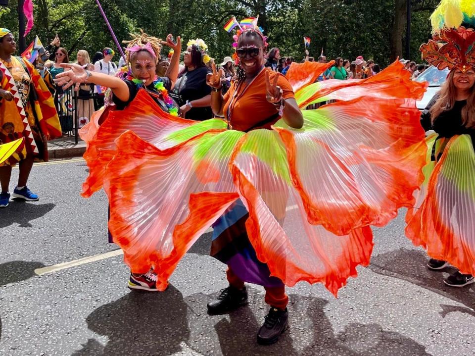 people in elaborate flower costumes in the streets during the london pride parade