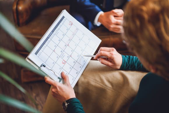 Woman holding a paper calendar on a clipboard