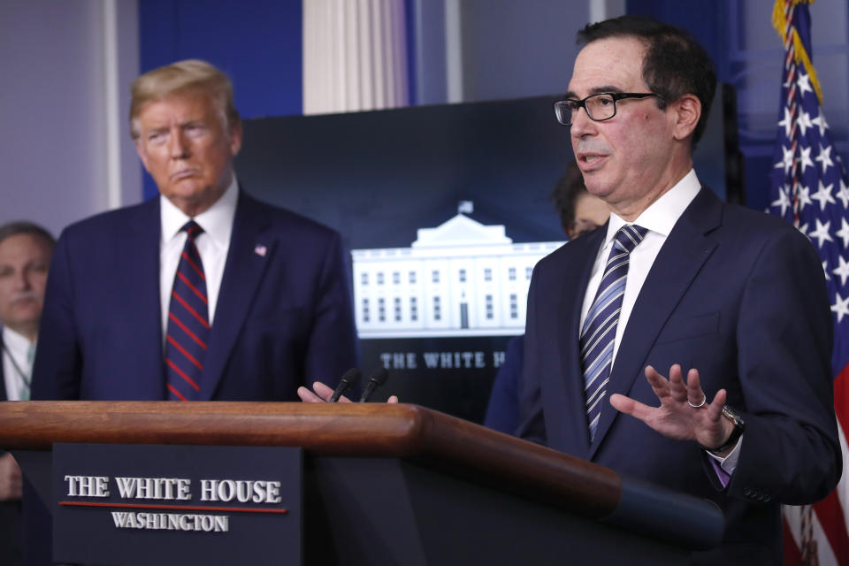 President Donald Trump listens as Treasury Secretary Steven Mnuchin speaks about the coronavirus in the James Brady Press Briefing Room of the White House, Thursday, April 2, 2020, in Washington. (AP Photo/Alex Brandon)