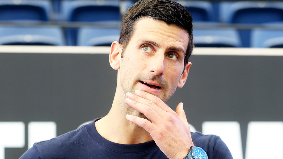 Novak Djokovic rubs his chin as he answers a question during a press conference in Adelaide.