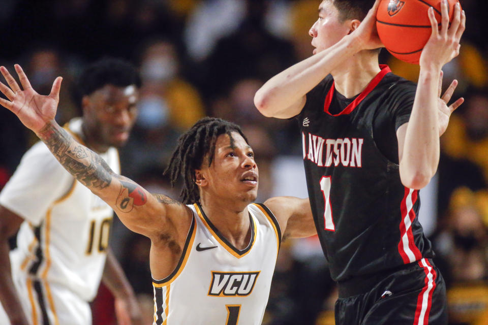 Virginia Commonwealth guard Adrian Baldwin Jr. (1) defends Davidson guard Hyunjung Lee (1) during the first half of an NCAA basketball game on Tuesday, Jan. 18, 2022, in Richmond, Va. (Shaban Athuman/Richmond Times-Dispatch via AP)