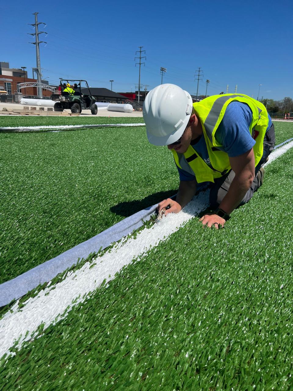 An employee with ForeverLawn works on the artificial surface being installed at the youth fields under construction at Hall of Fame Village in Canton. ForeverLawn is one of seven companies receiving the Business Excellence Award this Thursday from the Canton Regional Chamber of Commerce. (Submitted photo)