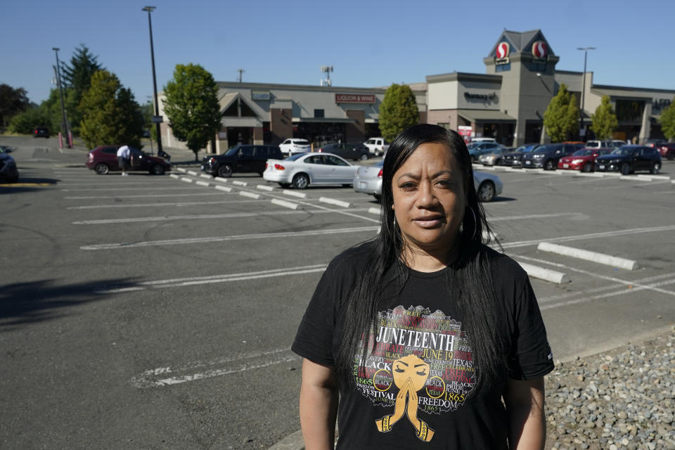 Marty Jackson, director of the SE Network, a community group whose work includes increasing the safety of community gathering places, poses for a photo, Tuesday, July 12, 2022, in the parking lot of a Safeway store in Seattle's Rainier Beach neighborhood, where her group holds weekly gatherings to provide food, referrals to services and "healing spaces" for people affected by violence. The work of Jackson's group falls under the umbrella of strategies known as community violence intervention, an approach backed by the Biden administration and donations from several major philanthropic foundations, which tries to stop local conflicts from escalating. (AP Photo/Ted S. Warren)