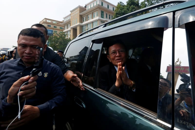 Cambodian opposition leader Kem Sokha greets as he leaves the Municipal Court of Phnom Penh