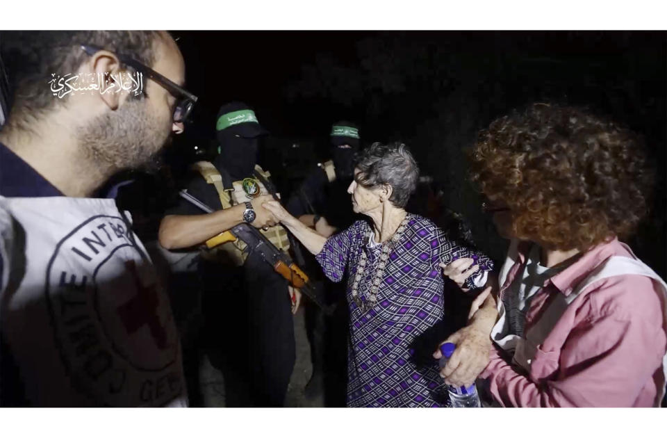 This image taken from video released by Al Qassam brigades on its Telegram channel, shows Yocheved Lifshitz, 85, shaking hands a thanking a member of Hamas as she is released to the Red Cross in an unknown location, Monday, Oct. 23, 2023. (Al Qassam brigades via AP)