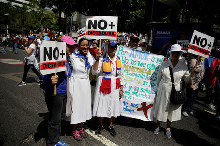 Catholic nuns hold placards reading "No more Dictatorship" during an opposition rally in Caracas, Venezuela April 6, 2017. REUTERS/Marco Bello