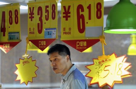 A man looks at a price tag as he shops at a supermarket in Hefei, Anhui province September 11, 2014. REUTERS/Stringer