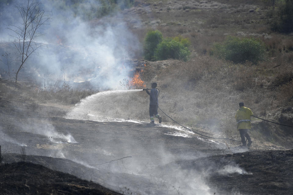 Firefighters work to extinguish fires set by incendiary ballons launched from the Gaza Strip, along the Israel-Gaza border, Friday, Sept. 22, 2023. Palestinians have been staging violent protests near the separation fence between Israel and Gaza in recent days. (AP Photo/Tsafrir Abayov)