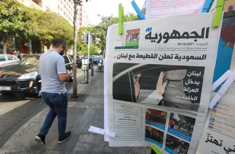 FILE PHOTO: Man walks near a newspaper with a headline that reads " Saudi Arabia announces a boycott with Lebanon" in Beirut