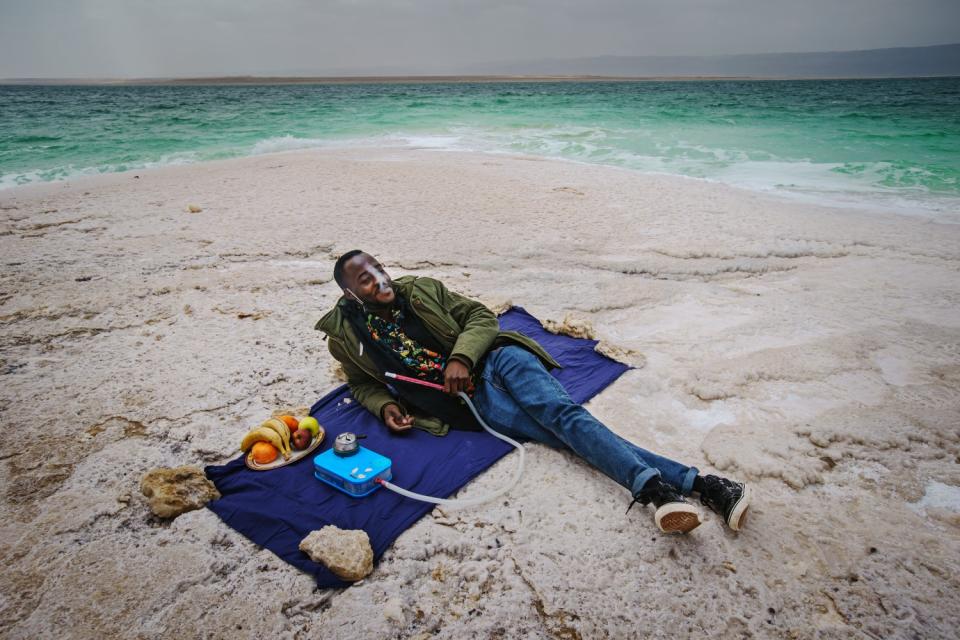 Nabeel Musa smokes as he picnics along the salt-encrusted shore of the Dead Sea.