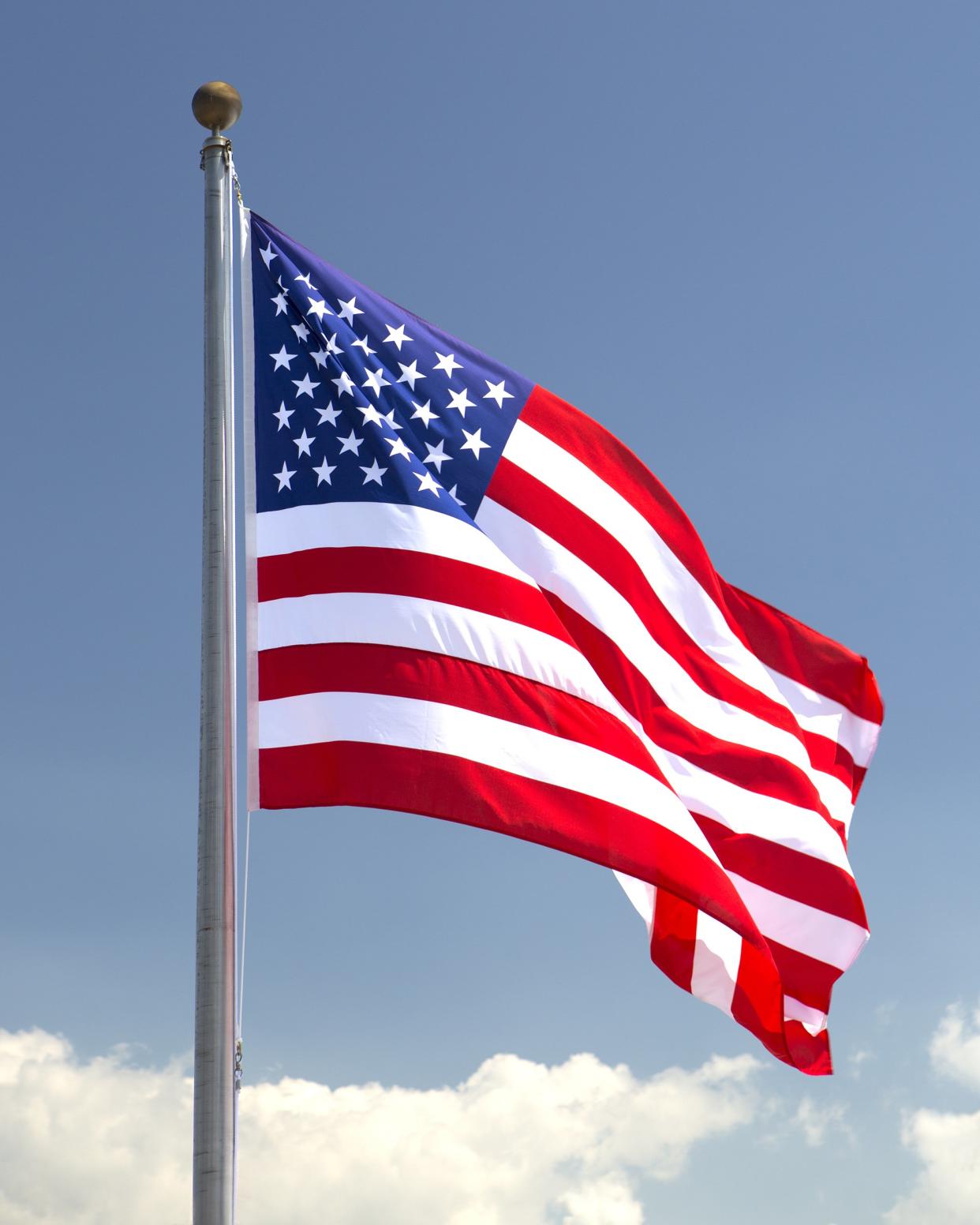 American flag blowing gently in the breeze with blue sky