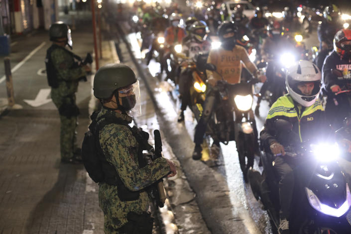 Police officers inspect motorcycle riders at a checkpoint during a stricter lockdown as a precaution against the spread of the coronavirus at the outskirts of Marikina City, Philippines on Friday, August 6, 2021. Thousands of people jammed coronavirus vaccination centers in the Philippine capital, defying social distancing restrictions, after false news spread that unvaccinated residents would be deprived of cash aid or barred from leaving home during a two-week lockdown that started Friday. (AP Photo/Basilio Sepe)