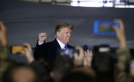 U.S. President Donald Trump pumps his fist at members of the U.S. military as he arrives to address them after his summit meeting with North Korea's Kim Jong Un in Vietnam during a refueling stop at Elmendorf Air Force Base in Anchorage, Alaska, U.S., February 28, 2019. REUTERS/Leah Millis