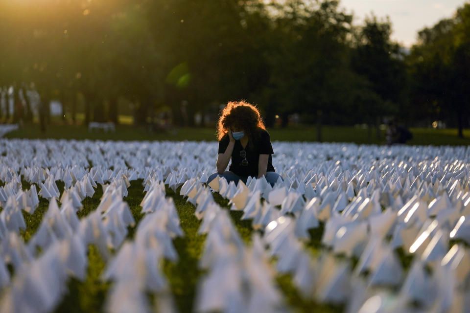 FILE - In this Sept. 17, 2021, file photo, Zoe Nassimoff, of Argentina, looks at white flags that are part of artist Suzanne Brennan Firstenberg's temporary art installation, "In America: Remember," in remembrance of Americans who have died of COVID-19, on the National Mall in Washington. Nassimoff's grandparent who lived in Florida died from COVID-19. (AP Photo/Brynn Anderson, File)