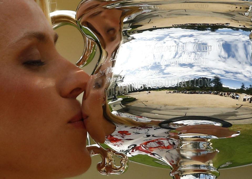 Germany's Angelique Kerber kisses the women's singles trophy a day after winning her final match at the Australian Open tennis tournament, at the Government House in Melbourne, Australia, January 31, 2016. REUTERS/Thomas Peter