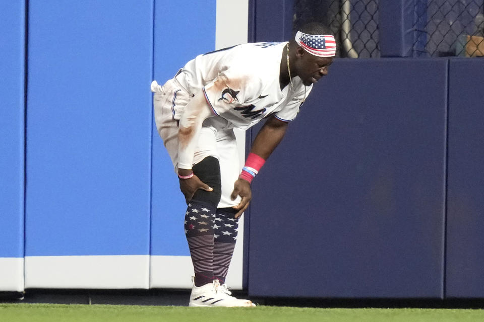 Miami Marlins center fielder Jonathan Davis holds his knee after an injury during the fifth inning of a baseball game against the St. Louis Cardinals, Tuesday, July 4, 2023, in Miami. (AP Photo/Lynne Sladky)