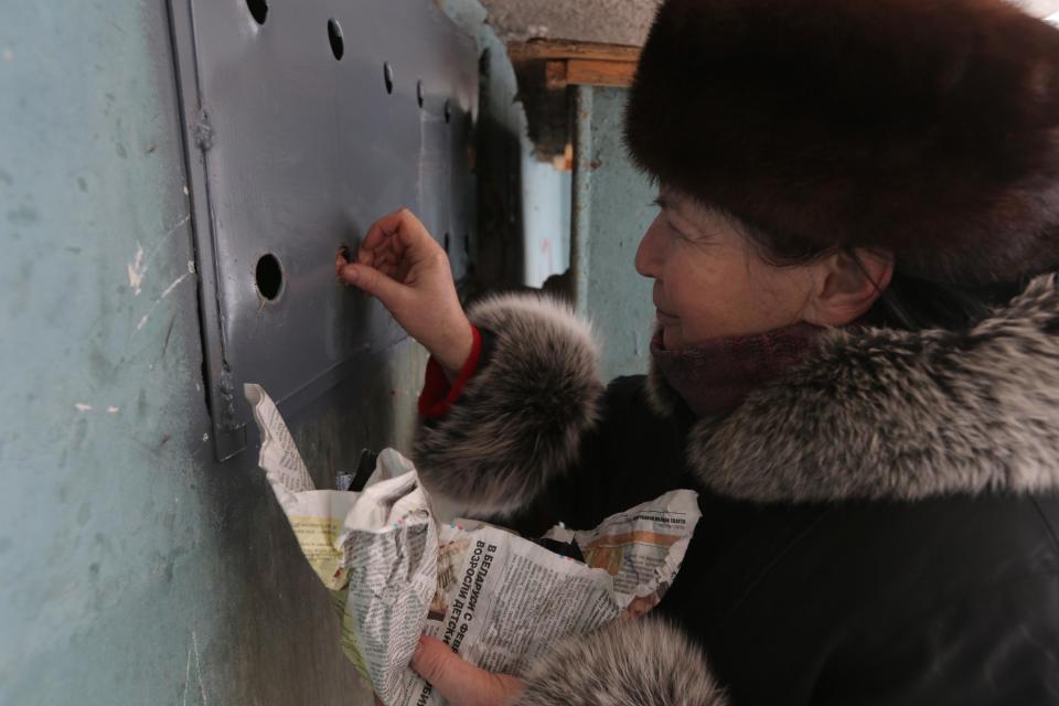 Antonina Gayenko feeds cats through holes in an iron panel covering a basement window in the Belarusian capital Minsk, Monday, Feb. 4, 2013. Municipal authorities in Belarus are walling up stray cats in basements in compliance with Soviet-era regulations, dooming them to death of hunger. Belarus doesn't have shelters for stray animals. Municipal authorities said they wall up doors to basements in line with sanitary norms introduced in 1990, when Belarus was still part of the USSR. (AP Photo/Sergei Grits)