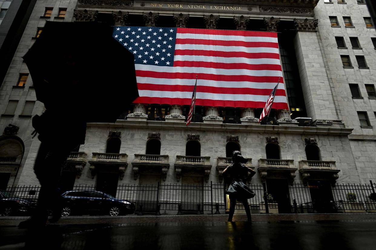 A woman walks past the New York Stock Exchange during the coronavirus pandemic: AFP via Getty Images