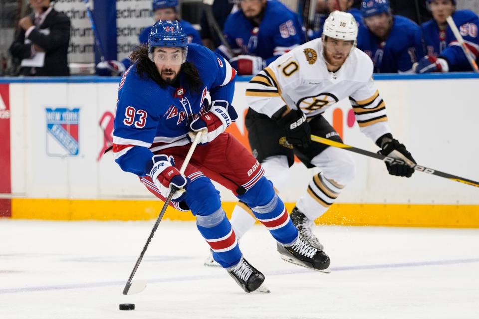 New York Rangers' Mika Zibanejad (93) looks to pass the puck as Boston Bruins' A.J. Greer (10) watches during the second period of an NHL preseason hockey game Thursday, Oct. 5, 2023, in New York.
