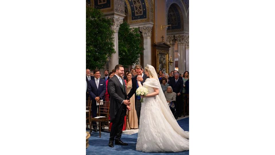 Prince Pavlos kissing sister Theodora's hand at the altar