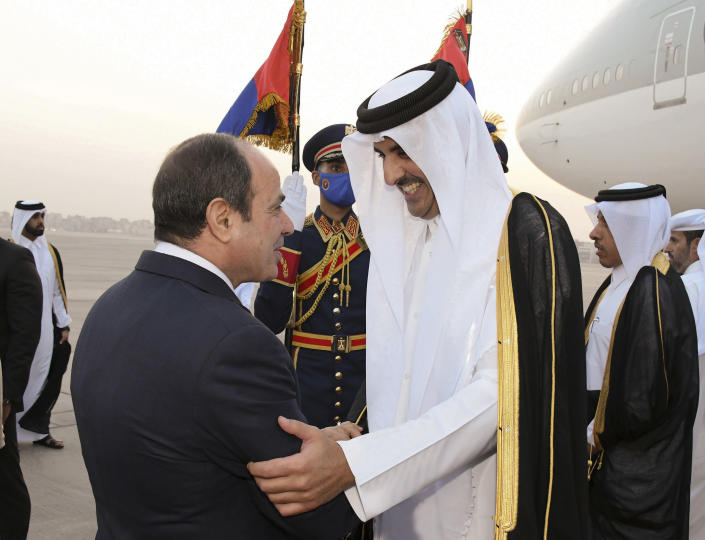 In this photo provided by Egypt's presidency media office, Egyptian President Abdel-Fattah el-Sissi, left, greets Qatari Emir Tamim bin Hamad Al Thani upon his arrival at Cairo airport, Egypt, Friday, June 24, 2022. Qatar's emir arrived in Cairo to hold talks with Egypt's president in his first visit since the two countries agreed to reset relations after more than seven years of diplomatic animosity. (Egyptian Presidency Media Office via AP)