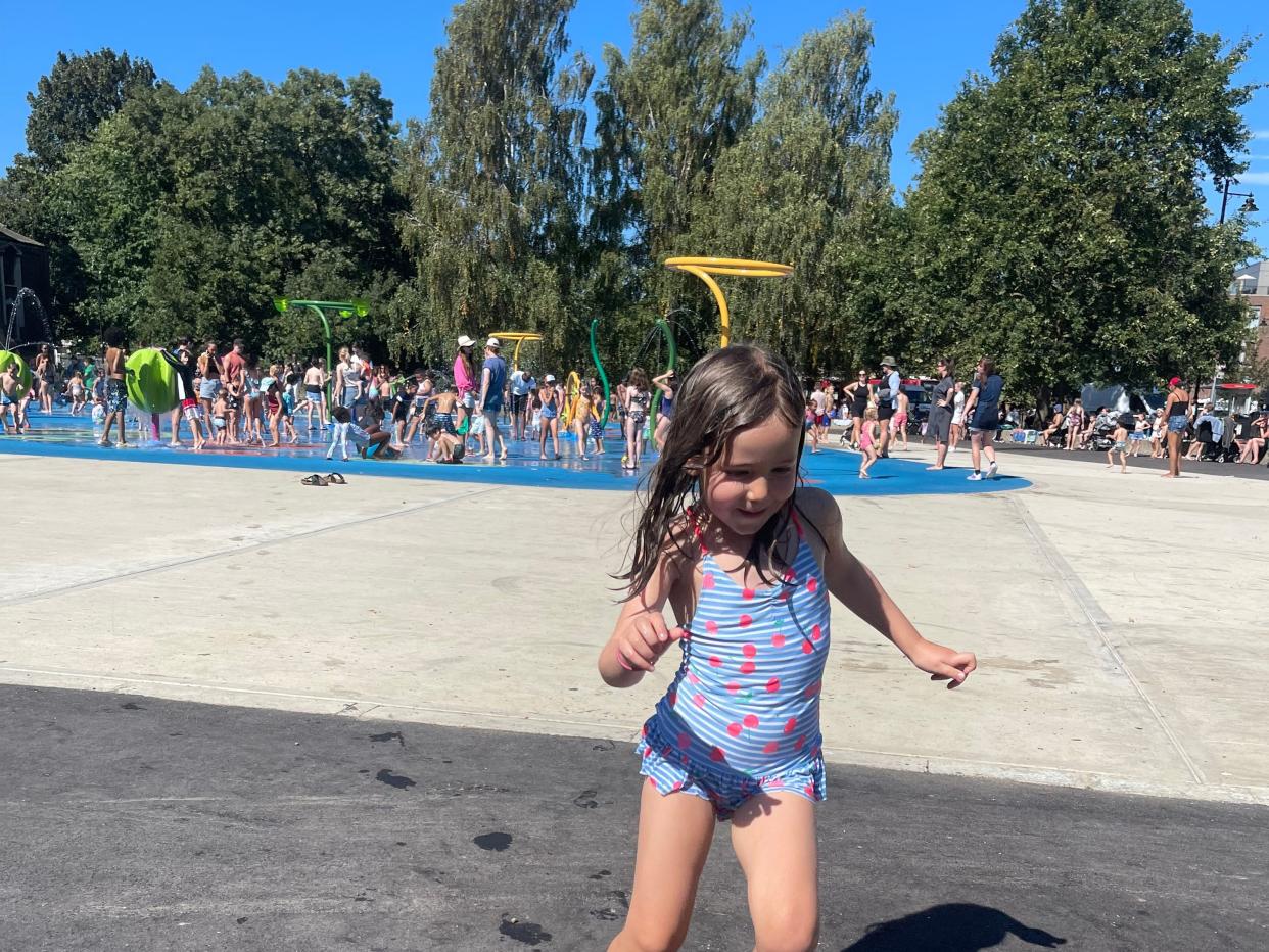 Girl playing at splash pad in London summer