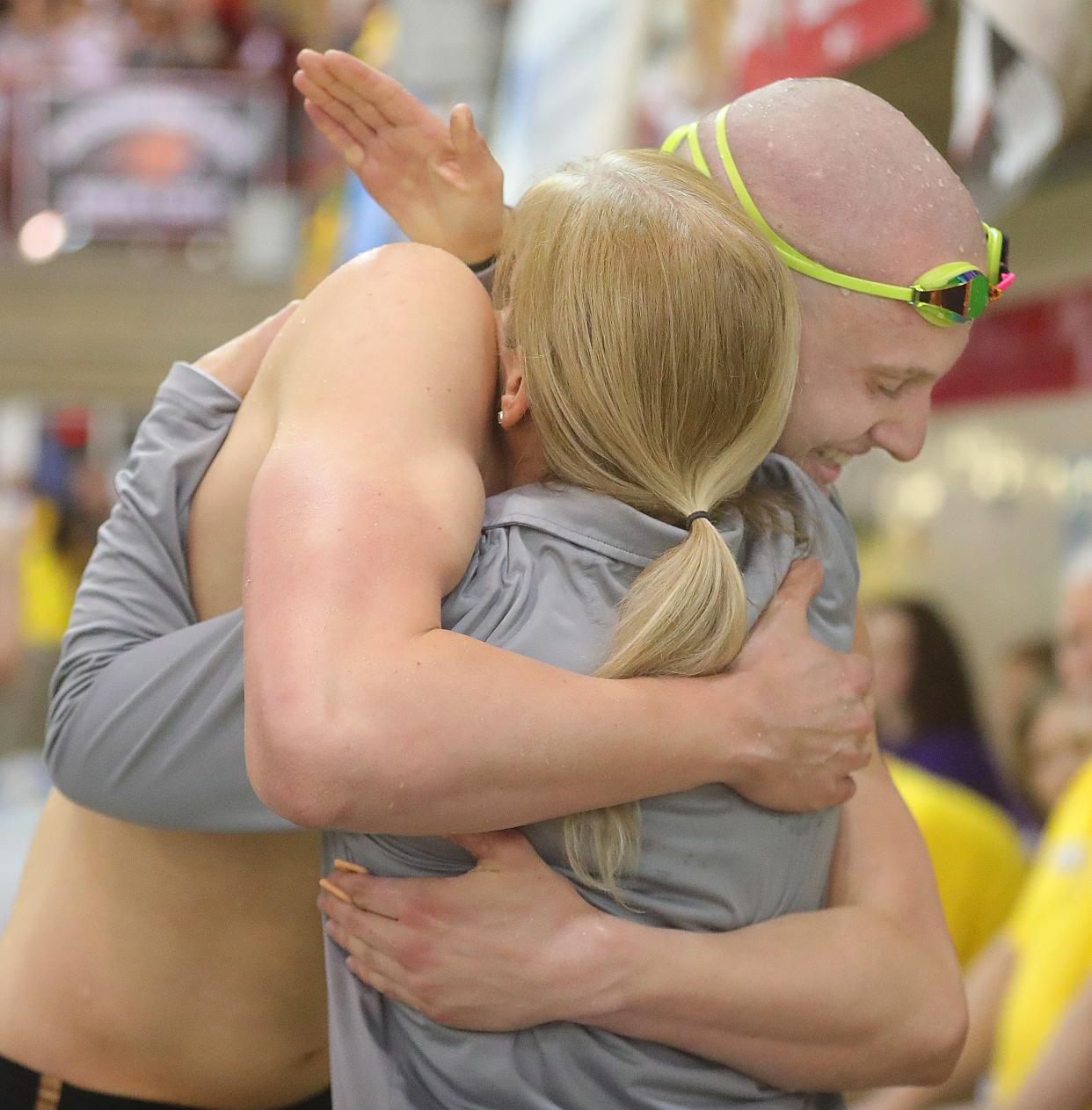 Firestone's Jonny Marshall gets a hug from head coach Cindy Dial after his state championship win in the 100-yard backstroke during the Division I state meet Saturday, Feb. 25, 2023 in Canton.