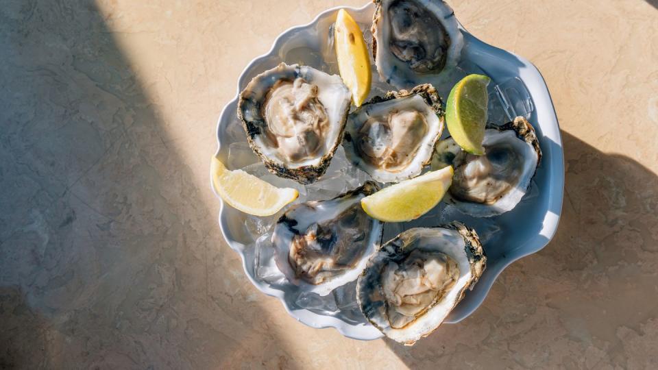 oysters with lime on ice on a plate, directly above view