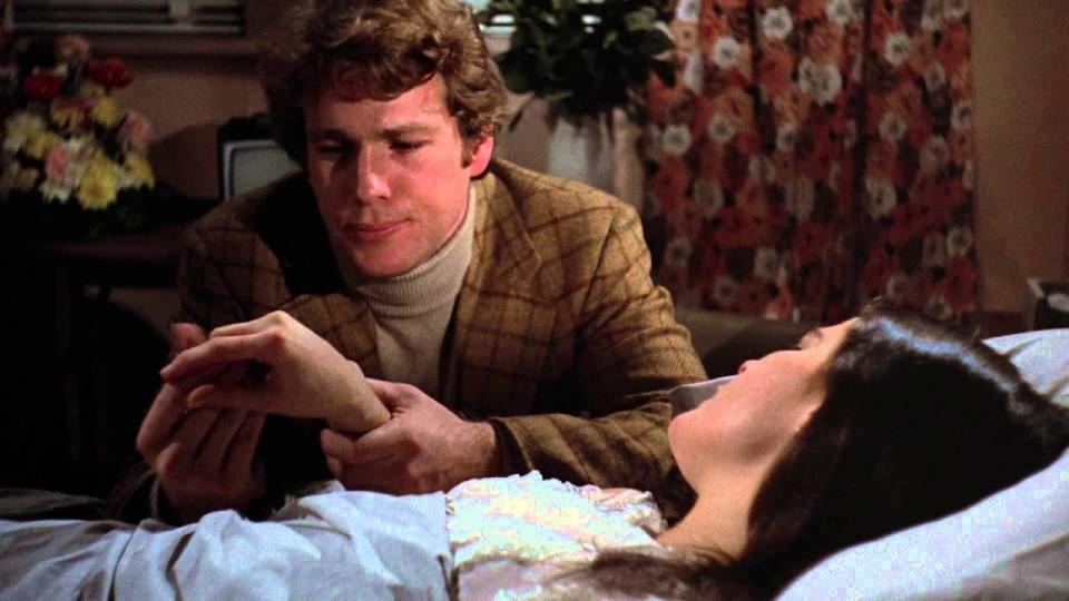 Oliver (Ryan O'Neal) holds Jenny's (Ali MacGraw) hand as she dies in 'Love Story'