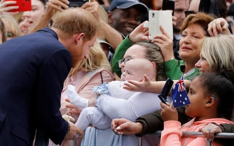 Father-to-be, the Duke of Sussex, is greeted by a baby among the crowd - Credit: Getty Images