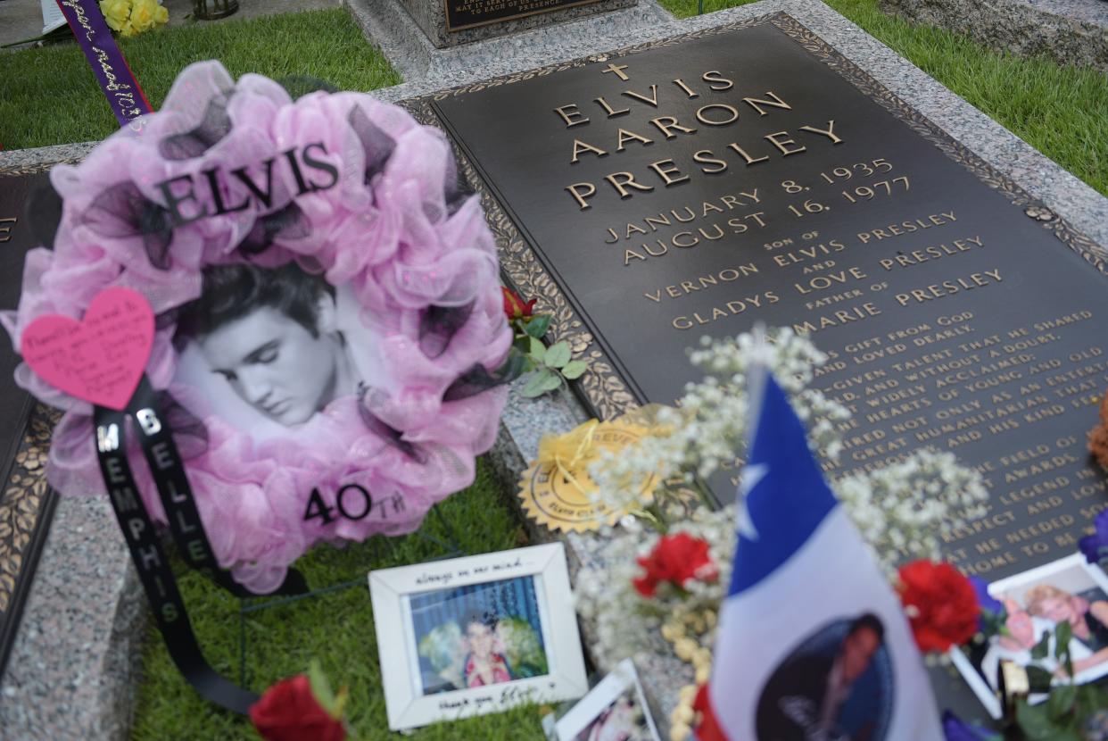 Tributes are seen beside the grave marker for Elvis Presley in the Meditation Garden where he's buried alongside his parents and grandmother at his Graceland mansion in this file photo from  August 12, 2017.