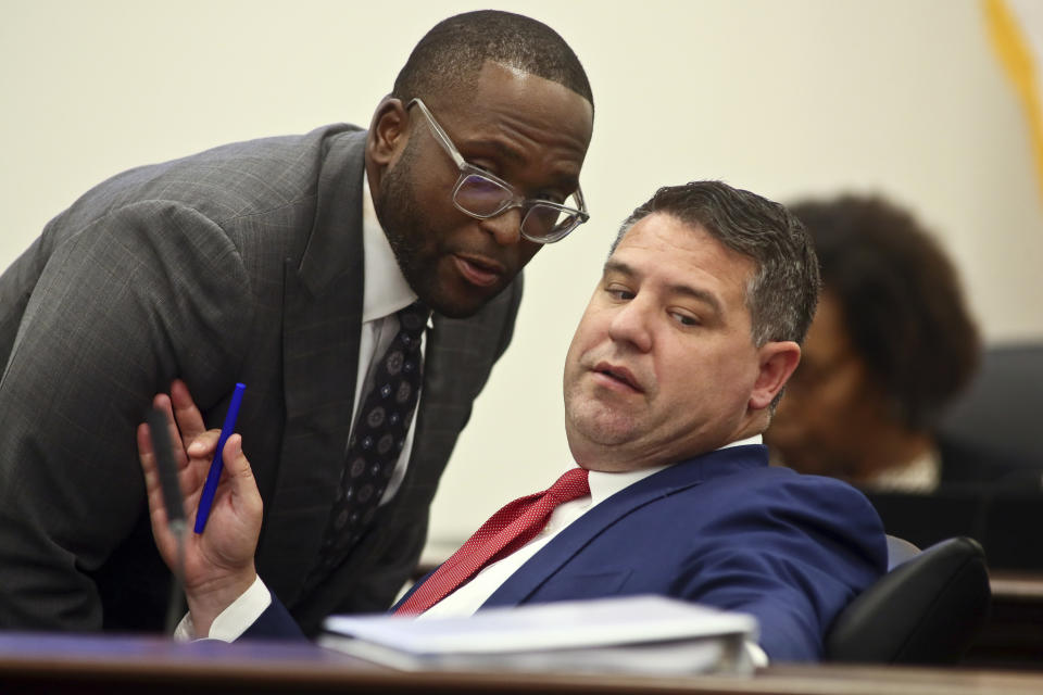 Sen. Shevrin Jones, D-West Park, left, confers with Sen. Travis Hutson, R-St. Augustine, right, during the Committee on Fiscal Policy meeting Monday, Dec. 12, 2022, at the Capitol in Tallahassee, Fla. Florida lawmakers are meeting to consider ways to shore up the state's struggling home insurance market in the year's second special session devoted to the topic. (AP Photo/Phil Sears)