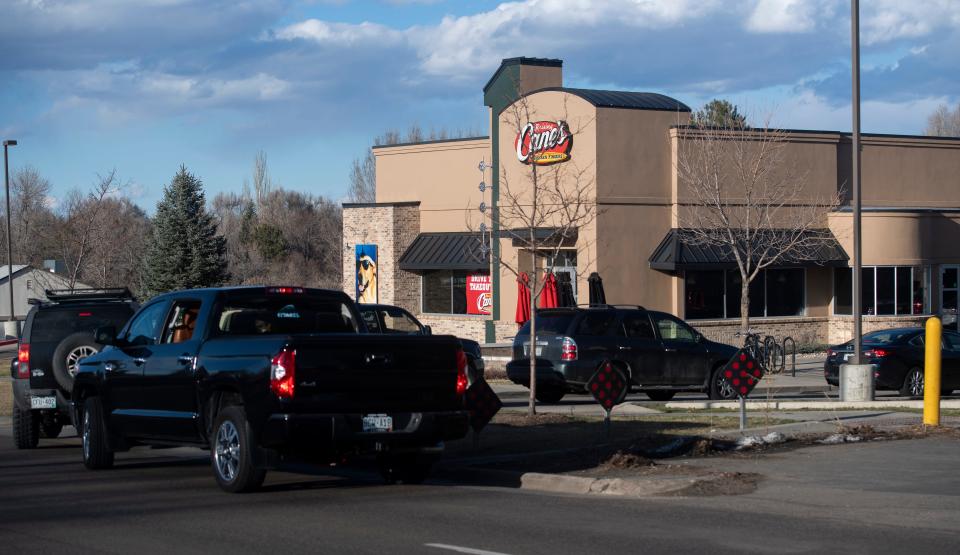 In this file photo, a line of cars stretches from Raising Cane's Chicken Fingers' drive-thru onto South College Avenue on March 22, 2020.