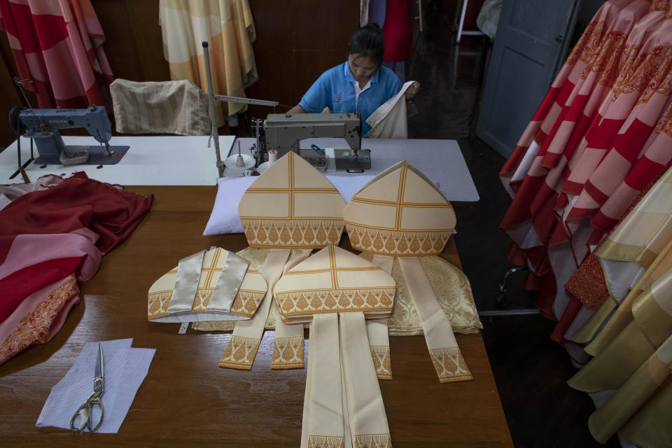 In this Friday, Nov. 8, 2019 photo, a seamstresses from the Congregation of the Sacred Heart of Jesus Sisters of Bangkok sews at a Catholic preparatory school in Bangkok, Thailand. The seamstresses are studiously snipping and sewing, fashioning robes for the upcoming visit of Pope Francis. They’ve been working tirelessly, running up the ceremonial garments Pope Francis will wear during his four-day visit to Thailand later this month. (AP Photo/Gemunu Amarasinghe)