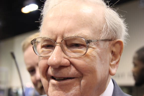 Headshot of Warren Buffett walking through a crowd.