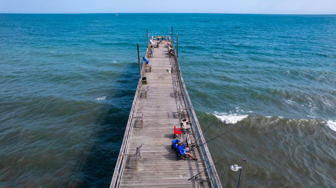 Visitors fish on the Sunset Beach pier in June 2022. Travis Long/tlong@newsobserver.com