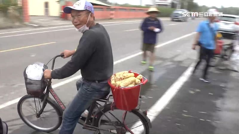 阿伯騎著單車要去送玉米給沿路的信眾。