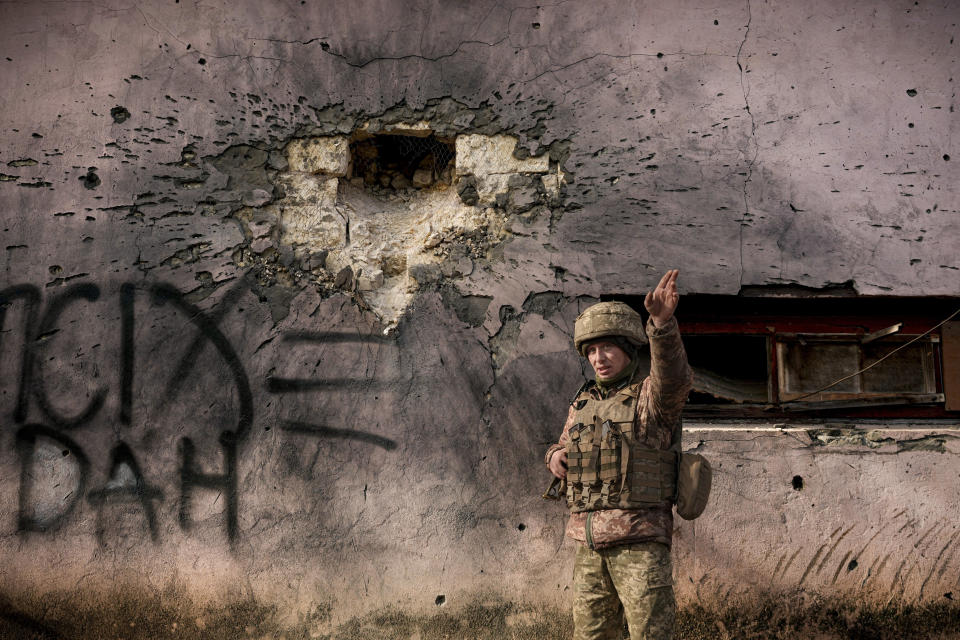 A Ukrainian serviceman points to the direction of the incoming shelling next to a building which was hit by a large caliber mortar shell in the frontline village of Krymske in the Luhansk region of eastern Ukraine on Saturday, February 19, 2022. / Credit: Vadim Ghirda / AP