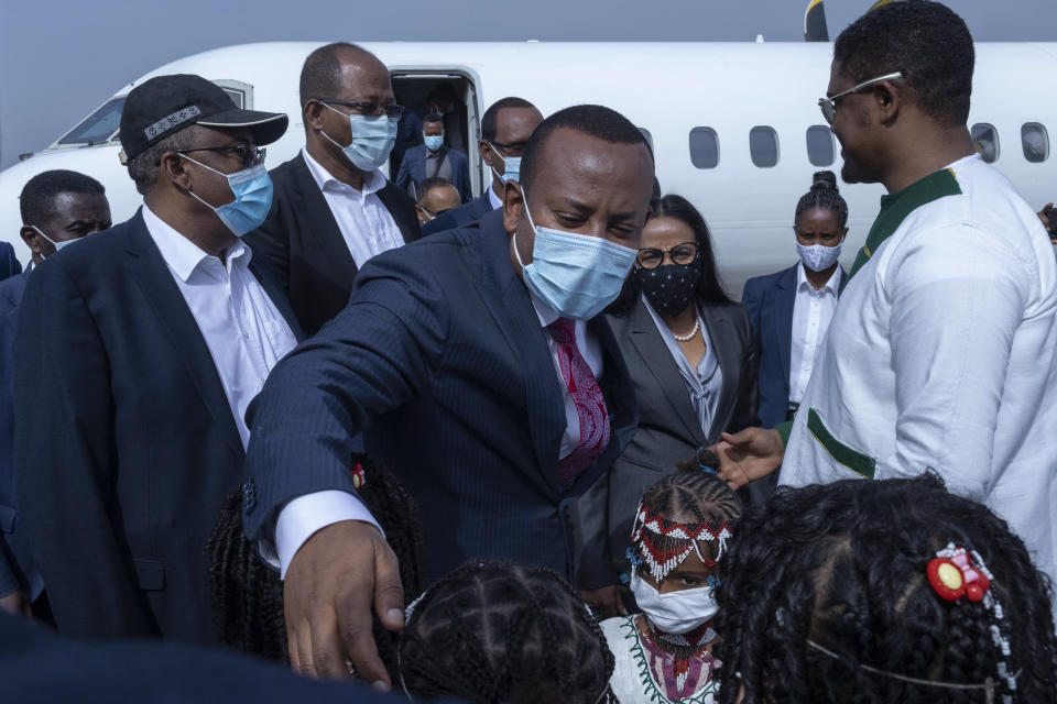 Ethiopia's Prime Minister Abiy Ahmed greets children holding flowers on his arrival at the airport, ahead of a final campaign rally, in the town of Jimma in the southwestern Oromia Region of Ethiopia Wednesday, June 16, 2021. The country is due to vote in a general election on Monday, June, 21, 2021. (AP Photo/Mulugeta Ayene)