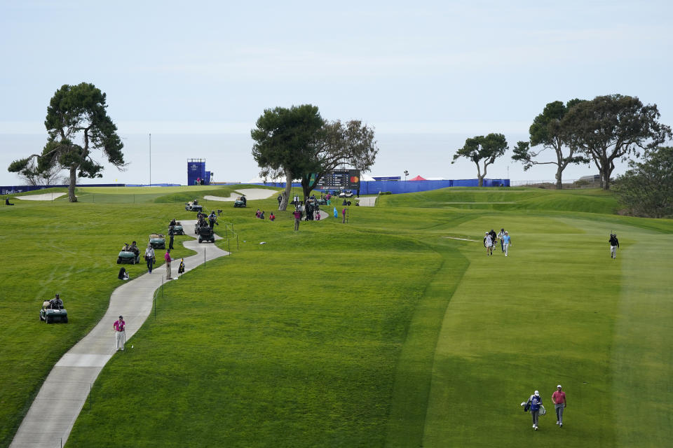 FILE - In this Jan. 31, 2021, file photo, Jon Rahm, lower right, of Spain, walks down with 13th fairway with his caddie, Adam Hayes, on the South Course during the final round of the Farmers Insurance Open golf tournament at Torrey Pines in San Diego. Rahm will return from self-isolation for a positive COVID-19 test in time for the U.S. Open at Torrey Pines on June 17-20. (AP Photo/Gregory Bull, File)