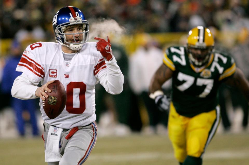 New York Giants quarterback Eli Manning looks to throw a pass as he runs from Green Bay Packers defensive end Cullen Jenkins (77) during the NFC Championship football game, Sunday, Jan. 20, 2008, in Green Bay, Wis. (AP Photo/David Duprey)
