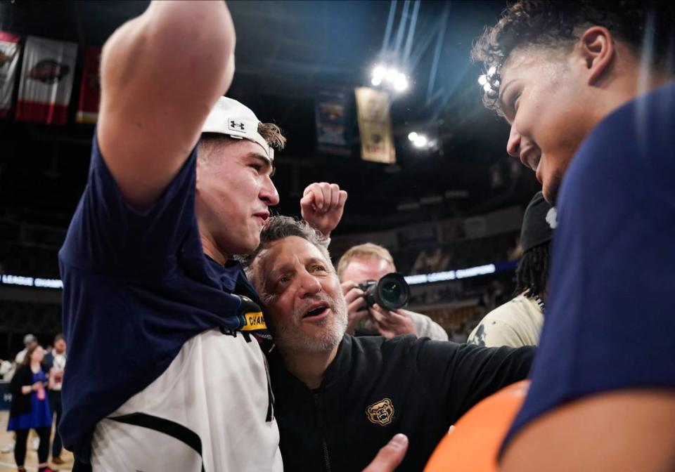 Oakland’s Blake Lampman (11) and head coach Greg Kampe celebrate after defeating Milwaukee for the Horizon League Tournament championship and a berth in the NCAA Tournament.