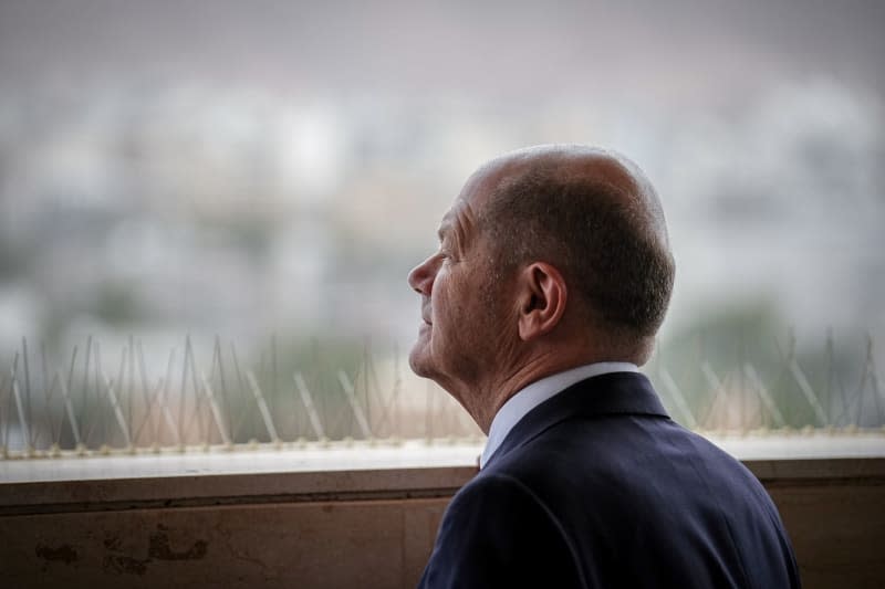 Germany's Chancellor Olaf Scholz looks over a hotel parapet at Aqaba after a meeting with the Jordanian King ahead of his visit to Israel. Kay Nietfeld/dpa