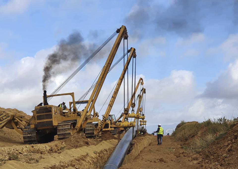 Heavy machines install a pipeline near Komotini town, northern Greece, Tuesday, Sept. 29, 2020. Crossing a remote border area of Greece and Bulgaria, a new pipeline nearing completion will help countries in the region dependent on Russian imports get greater access to the global natural gas market. The pipeline will ensure that large volumes of gas will flow between the two countries in both directions. (AVAX via AP)