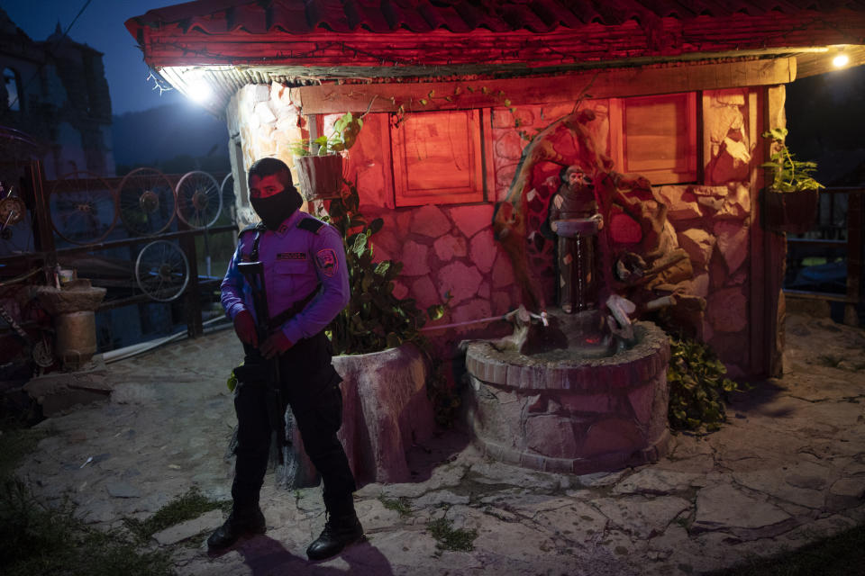 A policeman stands guard at the entrance of the mission and drug rehab center run by Friar Leopoldo Serrano, in Mission San Francisco de Asis, Honduras, Thursday, June 24, 2021. Father Serrano’s message is not widely popular. He has sought protection for his mission. (AP Photo/Rodrigo Abd)